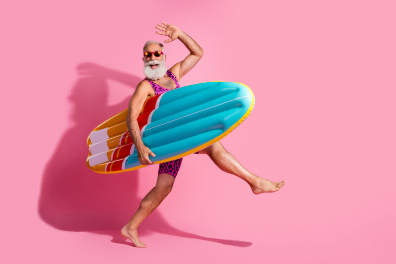 Photo Of Positive Optimistic Grandfather Wear Swimsuit Summer Vacation Resort Surfing Isolated On Pink Color Background